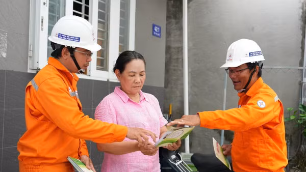Nhân viên Công ty Điện lực Đất Đỏ trực tiếp tuyên truyền, hướng dẫn người dân các biện pháp sử dụng điện an toàn trong mùa mưa bão. (Ảnh: DUY ĐOÀN)