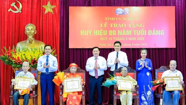 Các đồng chí trong Thường trực Tỉnh ủy Nghệ An trao Huy hiệu 80 năm tuổi Đảng và tặng hoa chúc mừng các đảng viên. (Ảnh: PHẠM BẰNG)