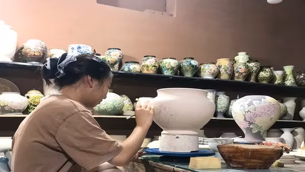 Vẽ hoa văn trên gốm tại một xưởng sản xuất gốm xã Bát Tràng, thành phố Hà Nội. (Ảnh: HÀ ANH)