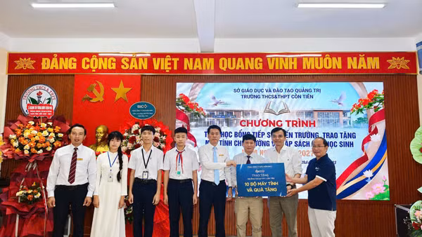 Đại diện Công ty Cổ phần Kaopiz Holdings và Báo Nhân Dân trao tặng máy tính cho Trường trung học cơ sở và trung học phổ thông Cồn Tiên. (Ảnh: Lâm Quang Huy)