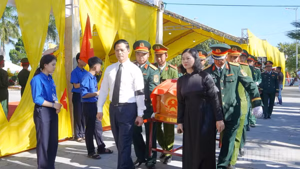 Các đại biểu tiễn đưa các liệt sĩ về nơi an nghỉ. (Ảnh: H.M)
