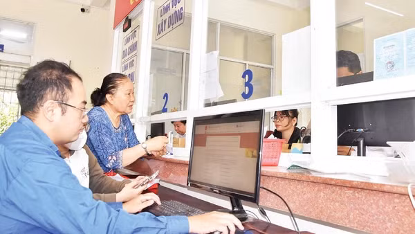 Cán bộ Trung tâm Phục vụ hành chính công phường Đạo Thạnh (tỉnh Đồng Tháp) hỗ trợ người dân xử lý hồ sơ trên môi trường số.