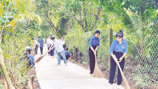 Đoàn viên, thanh niên và học sinh xã Phú Túc dọn vệ sinh tuyến đường nông thôn.