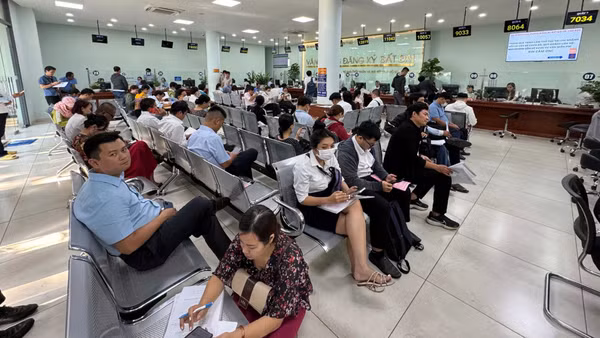 Người dân thực hiện thủ tục hành chính tại Văn phòng Đăng ký đất đai. (Ảnh: QUANG QUÝ)