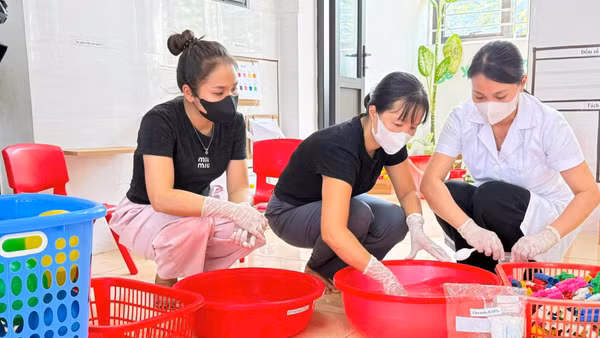 Cán bộ y tế, giáo viên Trường mầm non Tân Ước (xã Dân Hòa, Thành phố Hà Nội) thực hiện vệ sinh đồ chơi trước khi đón trẻ trên địa bàn bước vào năm học mới 2026-2027. Ảnh: VÂN SƠN