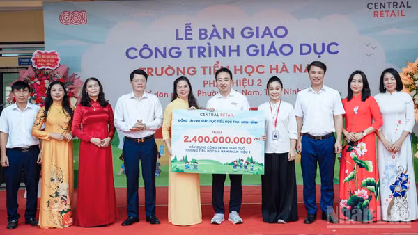 Các đại biểu thực hiện nghi thức trao bảng tài trợ tượng trưng cho nhà trường. (Ảnh: TÂN VŨ)
