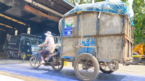 Công nhân chở rác tới trạm trung chuyển trước khi đưa đến khu vực xử lý. (Ảnh: QUANG QUÝ)