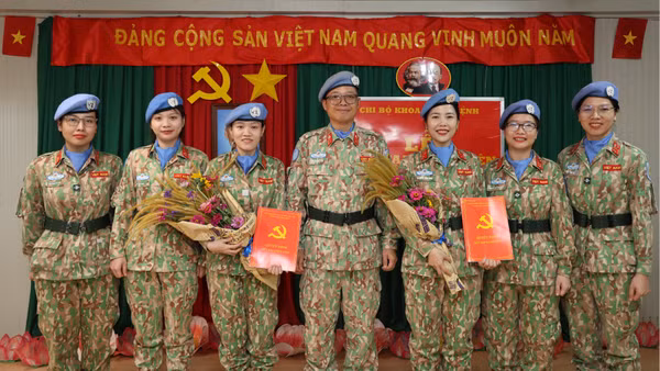 Trung tá, bác sĩ Trần Đức Tài (người đứng giữa), Bí thư Đảng ủy, Giám đốc Bệnh viện dã chiến cấp 2 số 7 và các đồng chí đảng viên Khoa Khám bệnh chúc mừng 2 đảng viên mới. (Ảnh: TIẾN PHÚC)