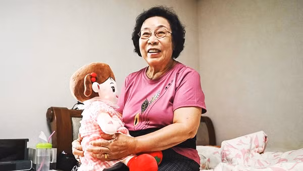 Bà Bang bên cạnh búp bê AI của mình. Ảnh: AFP