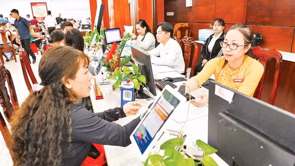 Người dân làm thủ tục hành chính tại xã Tân Nhựt (Ảnh THẾ ANH).