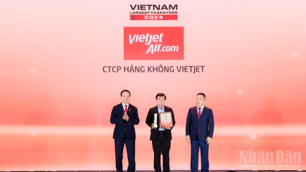 Ông Thái Trọng Cang, Kế toán trưởng Vietjet (đứng giữa) nhận bằng khen và cúp vinh danh doanh nghiệp dẫn đầu nhóm doanh nghiệp hàng không, logistics tư nhân nộp ngân sách lớn nhất Việt Nam năm 2025. (Ảnh: BẢO VY)