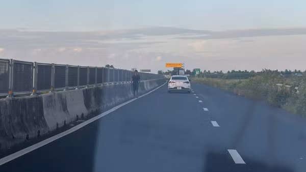 Người đi bộ băng qua làn đường cao tốc Lộ Tẻ-Rạch Sỏi tiềm ẩn nguy cơ tai nạn giao thông. ( Ảnh: Thanh Dũng)