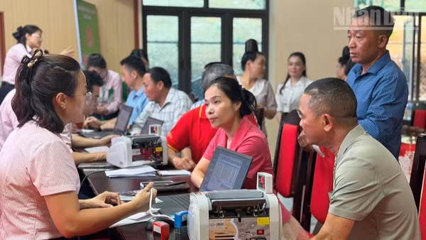 Cán bộ, nhân dân xã Búng Lao tham gia mở sổ tiết kiệm theo lời kêu gọi từ Phòng Giao dịch Ngân hàng Chính sách-xã hội Mường Ảng, tỉnh Điện Biên. (Ảnh: LÊ LAN)