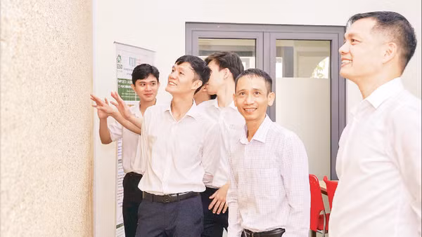 Giảng viên và sinh viên Trường đại học Giao thông vận tải Thành phố Hồ Chí Minh bên bức tường bê-tông gai dầu.