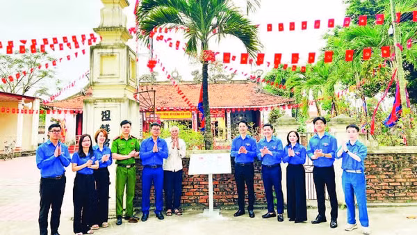 Đoàn viên thanh niên tổ chức gắn biển số hóa di tích tại Đình Đông Hội (Ảnh NINH BÌNH)
