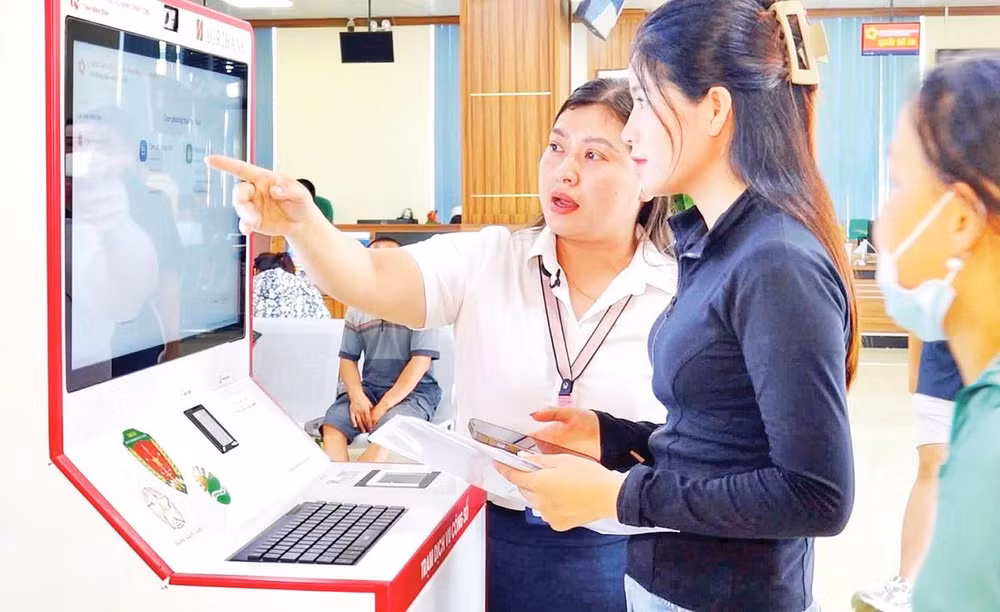 Cán bộ hướng dẫn người dân thực hiện thủ tục hành chính tại Trạm dịch vụ công số, Trung tâm Phục vụ hành chính công tỉnh Ninh Bình. 