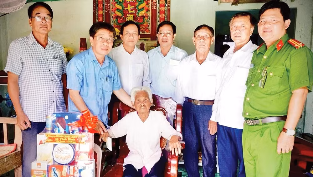Đại diện cán bộ xã Vĩnh Bình thăm hỏi và trao quà tặng hộ người có công.