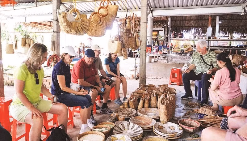 Du khách nước ngoài trải nghiệm làng nghề mỹ nghệ Tân Phong.