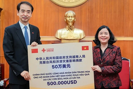 Đồng chí Bùi Thị Minh Hoài thay mặt Lãnh đạo Đảng, Nhà nước Việt Nam tiếp nhận số kinh phí hỗ trợ khắc phục hậu quả thiên tai, mưa lũ từ đồng chí Hà Vĩ, Đại sứ Trung Quốc tại Việt Nam. 