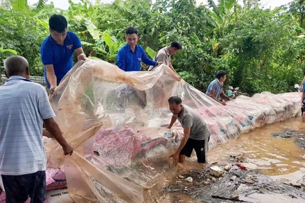 Đoàn viên, thanh niên tình nguyện hỗ trợ bà con đắp bờ chắn dòng chảy tại xã Nam Phù (Hà Nội).