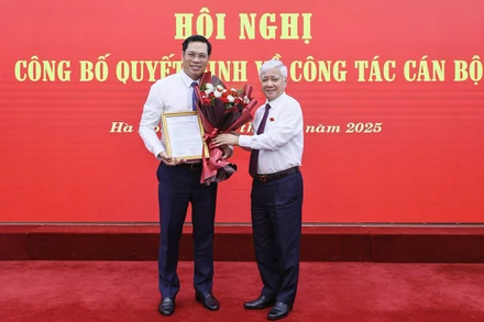 Đồng chí Đỗ Văn Chiến (bên phải) tặng hoa chúc mừng đồng chí Bùi Duy Đông.