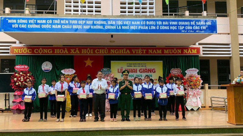 Đại diện xã Ia O và Ban Chỉ huy Bộ đội Biên phòng tỉnh trao quà cho các em học sinh tại lễ khai giảng.