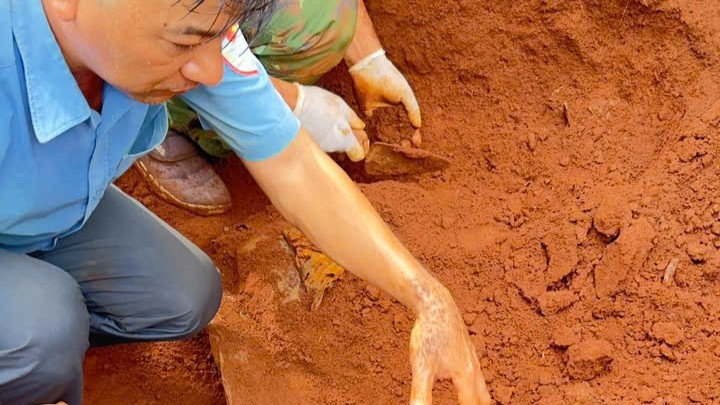 Cán bộ, chiến sĩ Đội K52 phối hợp với Ban Chỉ huy quân sự xã Ia Boòng cẩn thận cất bốc hài cốt liệt sĩ.