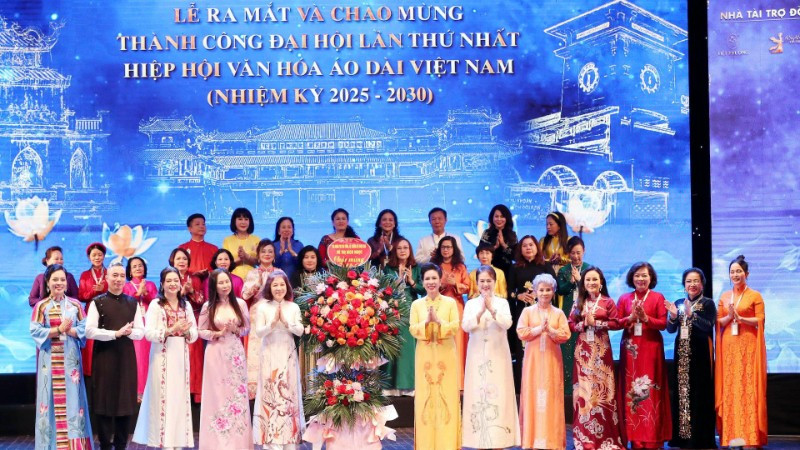 Chủ tịch Hiệp hội Văn hóa Áo dài Đặng Thị Bích Liên cùng thành viên Hiệp hội nhận hoa chúc mừng từ các đại biểu. (Ảnh: Ban tổ chức cung cấp)