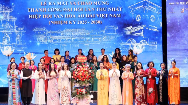 Chủ tịch Hiệp hội Văn hóa Áo dài Đặng Thị Bích Liên cùng thành viên Hiệp hội nhận hoa chúc mừng từ các đại biểu. (Ảnh: Ban tổ chức cung cấp)