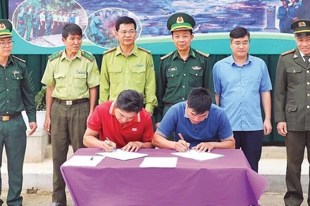 Đại diện nhân dân hai bản Pa Thơm (Điện Biên) và Na Luông (Lào) ký kết biên bản phối hợp phòng chống cháy rừng trong khu vực biên giới trước sự chứng kiến của chính quyền hai bên và Bộ đội Biên phòng tỉnh Điện Biên.