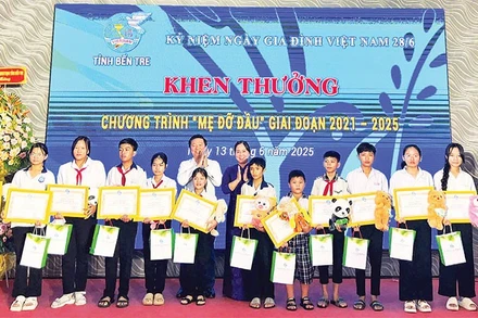 Hội Liên hiệp Phụ nữ tỉnh Bến Tre tặng quà, giấy khen cho các bé mồ côi có thành tích học tập tốt. (Ảnh HOÀNG TRUNG)