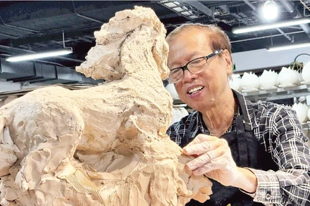 Nhà điêu khắc Nguyễn Kim Xuân bên một tác phẩm dành cho năm Bính Ngọ 2026.