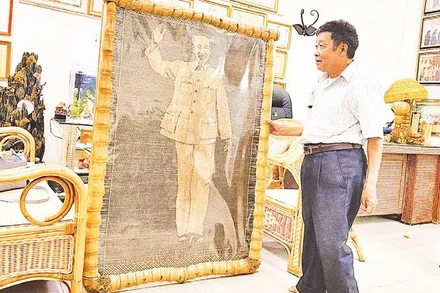 Nghệ nhân nhân dân Nguyễn Văn Trung bên bức chân dung Bác Hồ bằng mây tre vừa hoàn thiện.