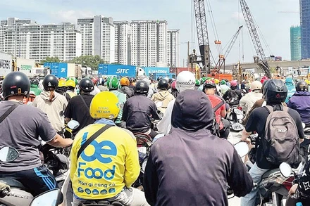 Dòng phương tiện phải chờ đợi rất lâu để di chuyển qua giao lộ Mai Chí Thọ-Lương Định Của. (Ảnh HƯƠNG MỸ)