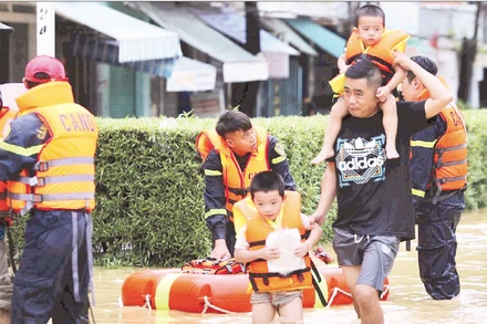 Lực lượng chức năng tỉnh Khánh Hòa ứng cứu di chuyển người dân ở phường Tây Nha Trang đến nơi an toàn.