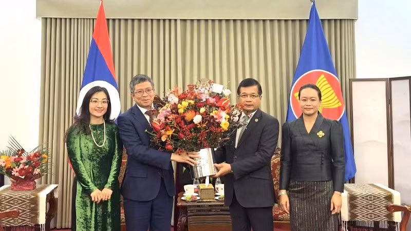 Đại sứ Phạm Thanh Bình tặng hoa chúc mừng Đại sứ quán Lào. (Ảnh: Đại sứ quán Việt Nam tại Trung Quốc)
