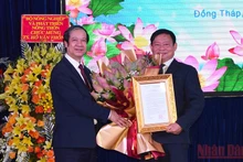 Bộ trưởng Nguyễn Kim Sơn trao Quyết định và tặng hoa chúc mừng tân Hiệu trưởng Trường Đại học Đồng Tháp Hồ Văn Thống.