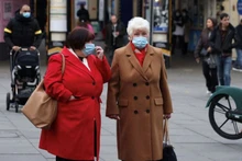 Người dân đeo khẩu trang chờ sang đường ở London, Anh, ngày 21/12/2021. (Ảnh: Reuters)