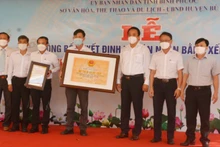 Lãnh đạo Sở Văn hóa, Thể thao và Du lịch tỉnh Bình Phước trao bằng xếp hạng Di tích lịch sử quốc gia địa điểm thảm sát ở Bù Đốp (16/3/1978) cho đại diện địa phương.