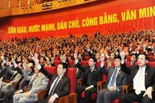 Các đại biểu biểu quyết thông qua Nghị quyết Đại hội lần thứ XII của Đảng. Ảnh: TRẦN HẢI