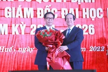 Bộ trưởng Giáo dục và Đào tạo Nguyễn Kim Sơn trao Quyết định, tặng hoa chúc mừng Giám đốc Đại học Huế Lê Anh Phương (bên trái ảnh).