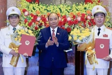 Chủ tịch nước Nguyễn Xuân Phúc trao Quyết định thăng cấp bậc hàm từ Trung tướng lên Thượng tướng đối với Thứ trưởng Công an Trần Quốc Tỏ và Lương Tam Quang. (Ảnh: Thống Nhất/TTXVN)