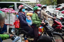 Em bé cũng theo bố mẹ cùng đồ đạc lỉnh kỉnh về quê ăn Tết. (Ảnh: Thành Đạt) 
