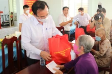 Đồng chí Nguyễn Văn Nên, Ủy viên Bộ Chính trị, Bí thư Thành ủy TP Hồ Chí Minh (bên trái) trao quà tặng người dân.