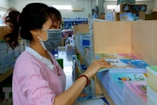Nhân viên soạn sách giáo khoa theo đơn đặt hàng của khách. (Ảnh: Thu Hiền/TTXVN)