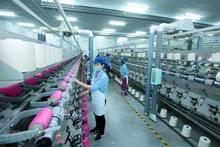 Công nhân sản xuất sản phẩm dệt nhuộm tại Công ty TNHH Dệt nhuộm Jasan Việt Nam. Ảnh: Phạm Kiên/TTXVN
