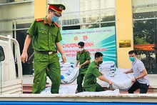 Cán bộ, chiến sĩ trẻ của lực lượng công an Thủ đô vận chuyển lương thực, nhu yếu phẩm từ nơi tập kết đến các khu dân cư.