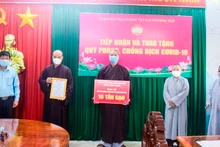 Đại diện Ban Trị sự Phật giáo Việt Nam huyện Châu Thành trao tặng bảng tượng trưng 10 tấn gạo.
