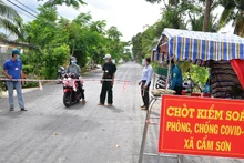 Người dân và lực lượng chức năng bảo vệ chốt “vùng xanh” tại xã Cẩm Sơn, huyện Cai Lậy (Tiền Giang).