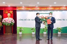 Bí thư Đảng ủy khối doanh nghiệp Trung ương Nguyễn Long Hải (trái) trao quyết định và tặng hoa chúc mừng đồng chí Phạm Quang Dũng, Ủy viên Ban Chấp hành Đảng bộ Khối doanh nghiệp Trung ương, tân Bí thư Đảng ủy Vietcombank.